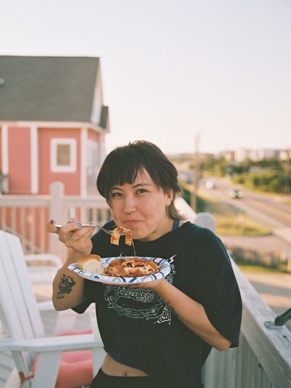 Student eating on a balcony at sunset