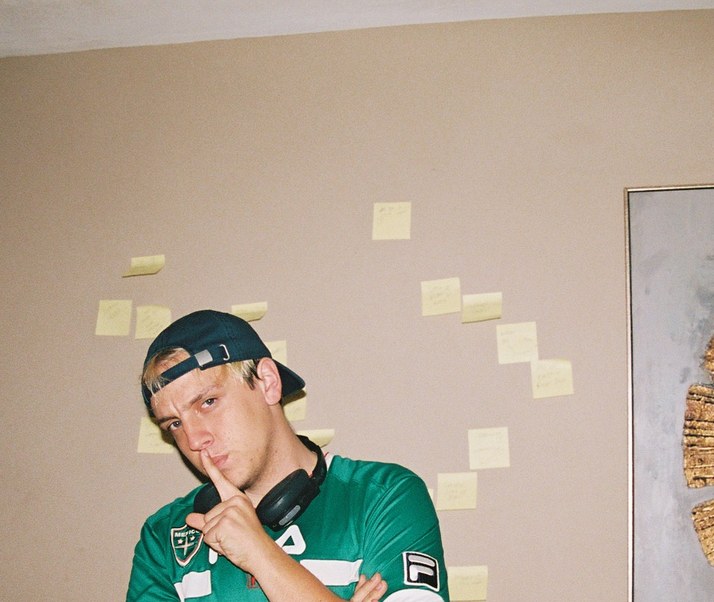 Student in a green jersey with sticky notes on the wall
