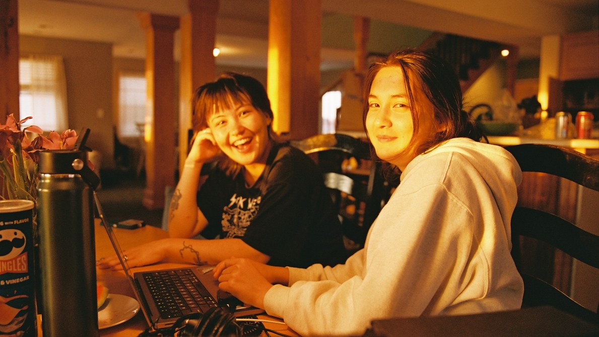 Students laughing while working on a laptop