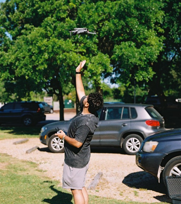 Student launching a drone outdoors