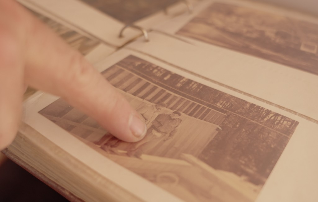 Patrick Harrison flips through archival photos of the construction of the Rapscallion, one of the first projects he took part in under his apprenticeship. He points out Robin Smith and Glen u201cPeanutu201d Haught.