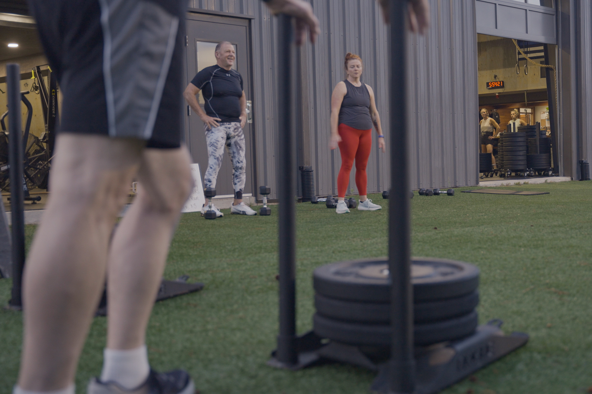 Charlie stands leaning against the training sled as he listens to the instructions by his trainer. They praise him th…