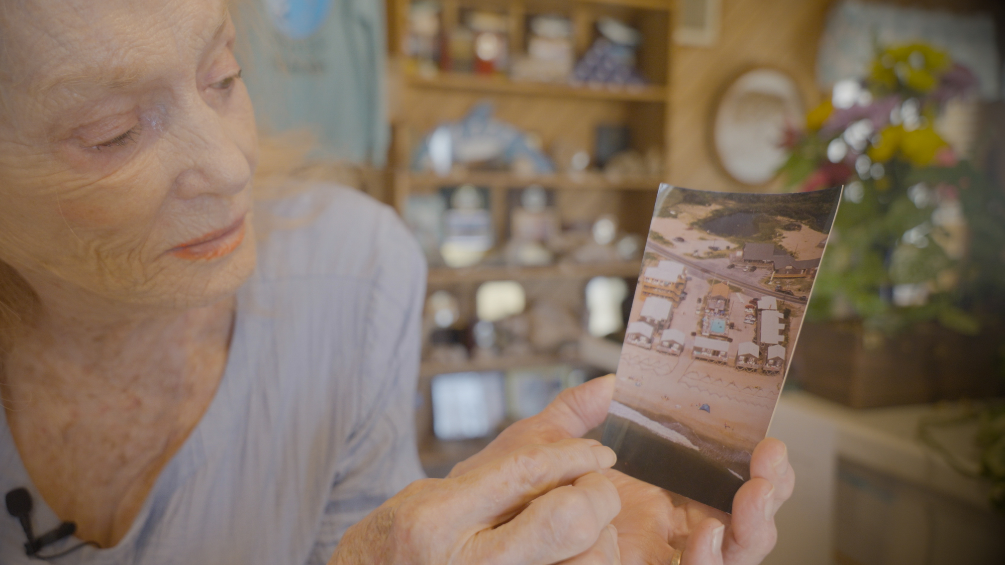 Dillon holds a postcard showing what the motel used to look like decades ago. When she and her husband started the mo…