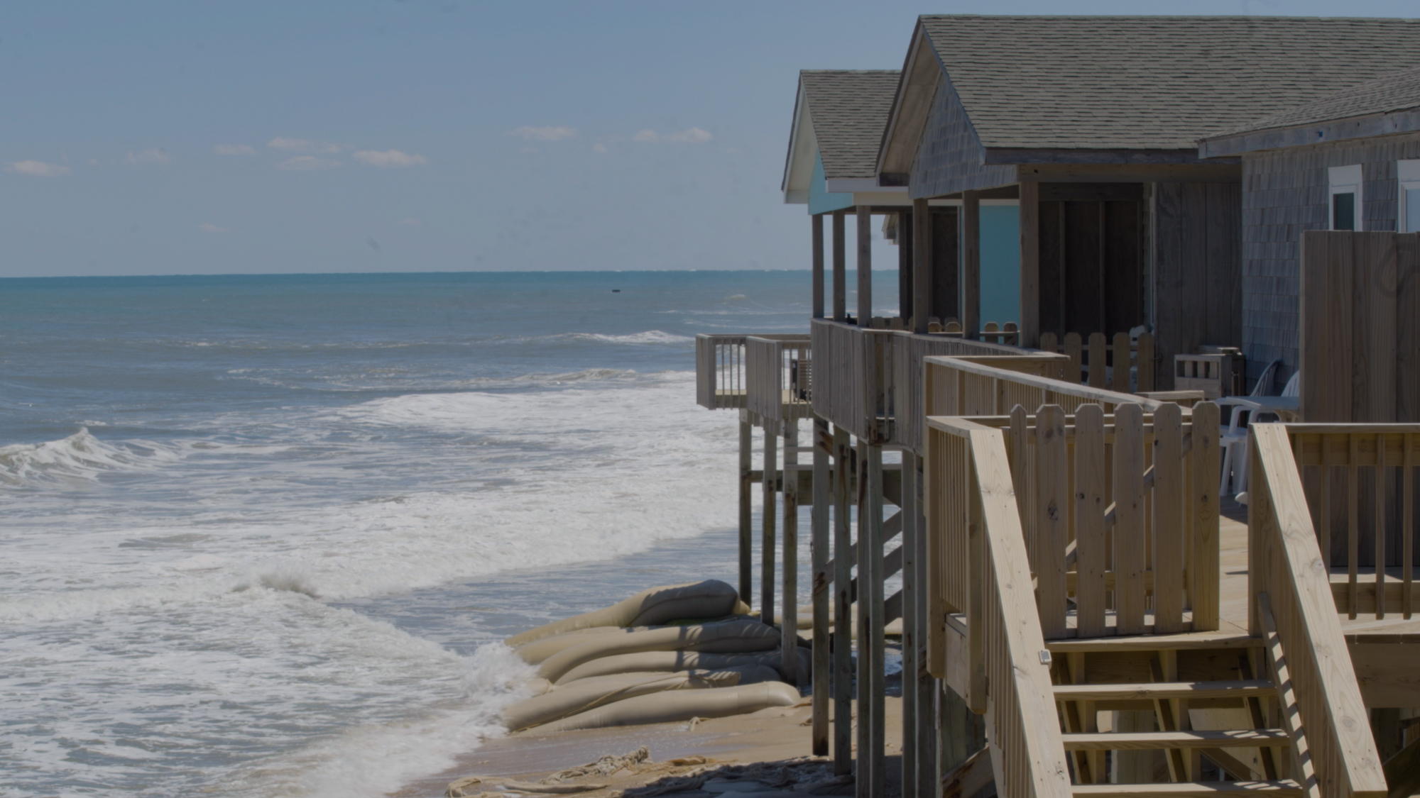 Sandbags lay across the beach in front of the motel. They are meant to keep the rapid coastal erosion at bay so the u…